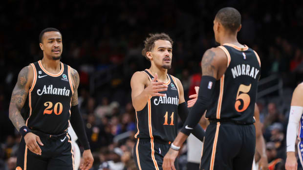 John Collins, Trae Young, and Dejounte Murray celebrate a play.